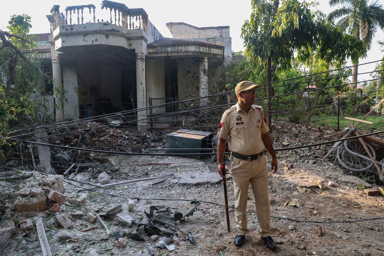 Un agente de Policía indio se encuentra frente a una casa en Jammu, Cachemira administrada por India, que resultó dañada por un bombardeo nocturno procedente de Pakistán el sábado 10 de mayo de 2025.