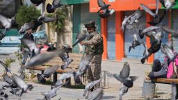 Un soldado indio alimenta palomas en un mercado de Srinagar, en Cachemira istrada por la India, el domingo.