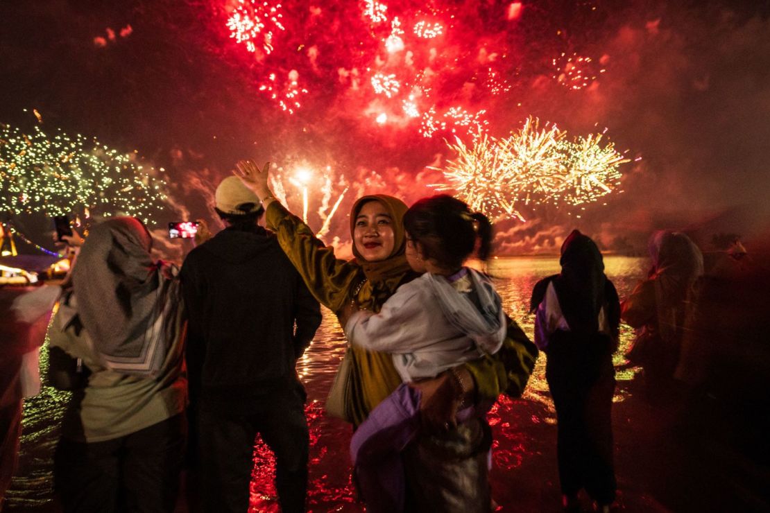 Los residentes observan los fuegos artificiales en la playa Ancol de Yakarta, Indonesia.