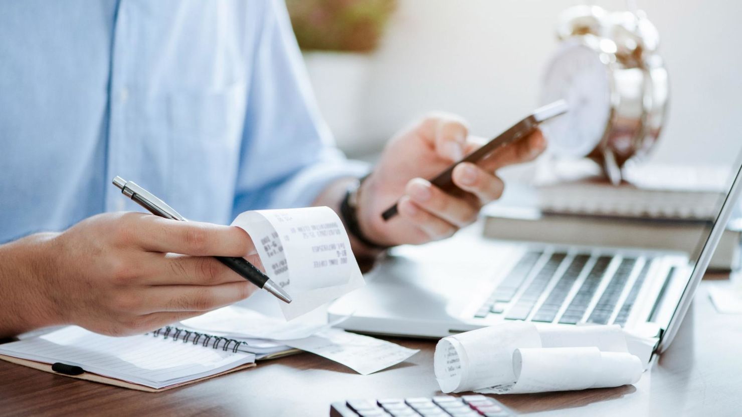 Person balances receipts and bills.