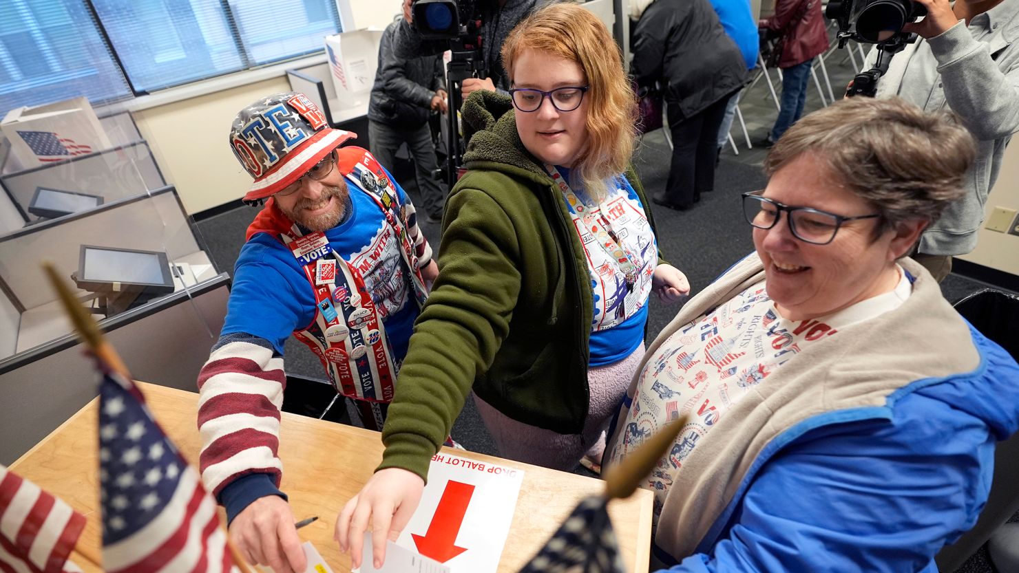 John Olsen, from left, his daughter Alice and his wife Ruby, of Ankeny, Iowa, cast their ballots during early voting at the Polk County Election Office on October 16 in Des Moines, Iowa.
