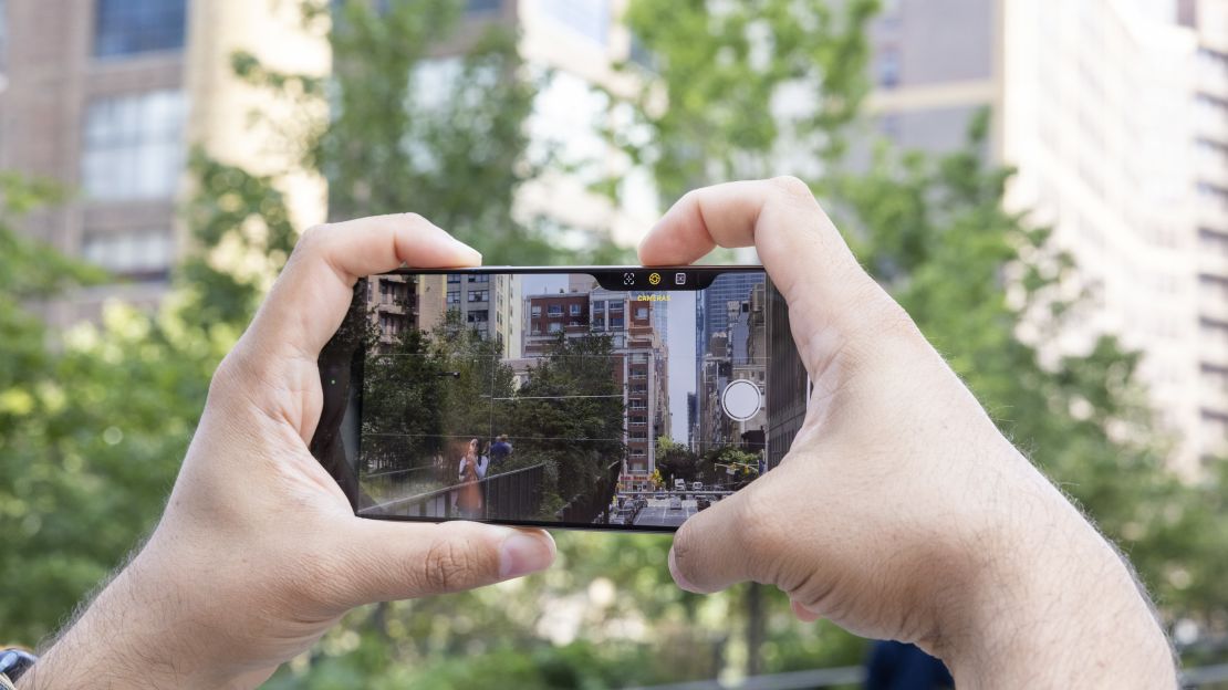 Someone is taking a photo with the iPhone 16 Pro, and their right hand has activated the Camera Control button