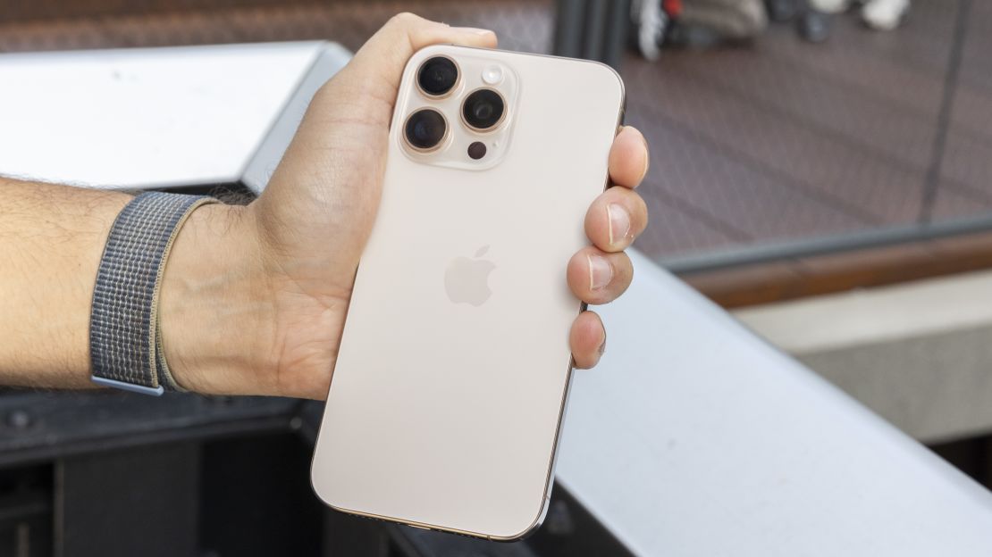 The Desert Titanium iPhone 16 Pro Max held in a hand