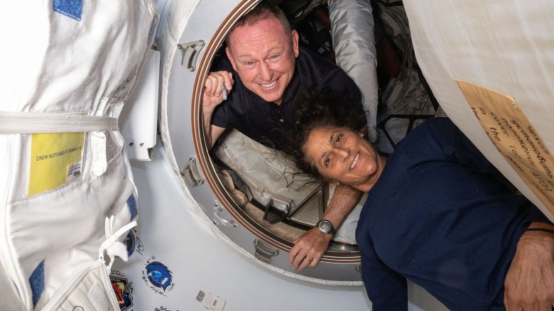 iss071e183650 (June 13, 2024) --- NASA's Boeing Crew Flight Test astronauts (from top) Butch Wilmore and Suni Williams pose for a portrait inside the vestibule between the forward port on the International Space Station's Harmony module and Boeing's Starliner spacecraft.