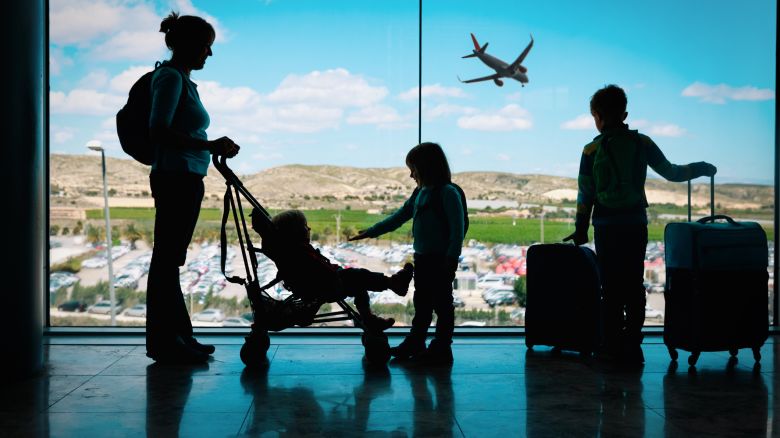 A photo of a mother watching her kids in an airport terminal