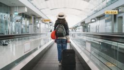 A photo of a person walking through an airport with a suitcase