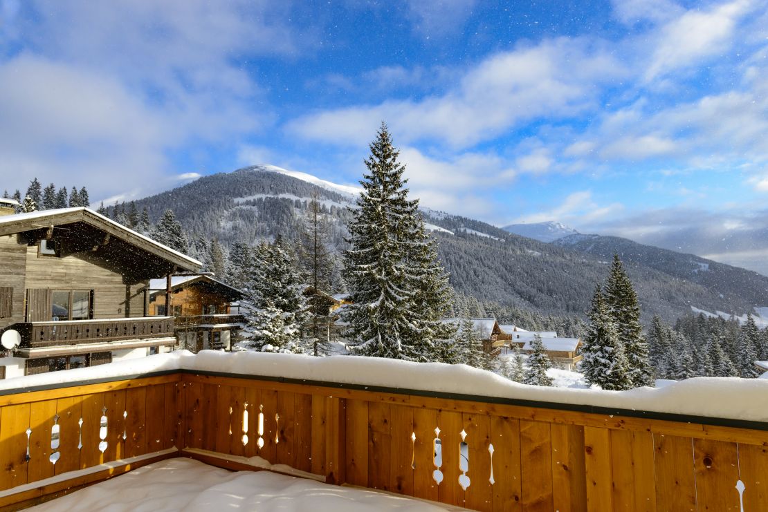 A photo of the view of snow-covered Austrian alps from a balcony