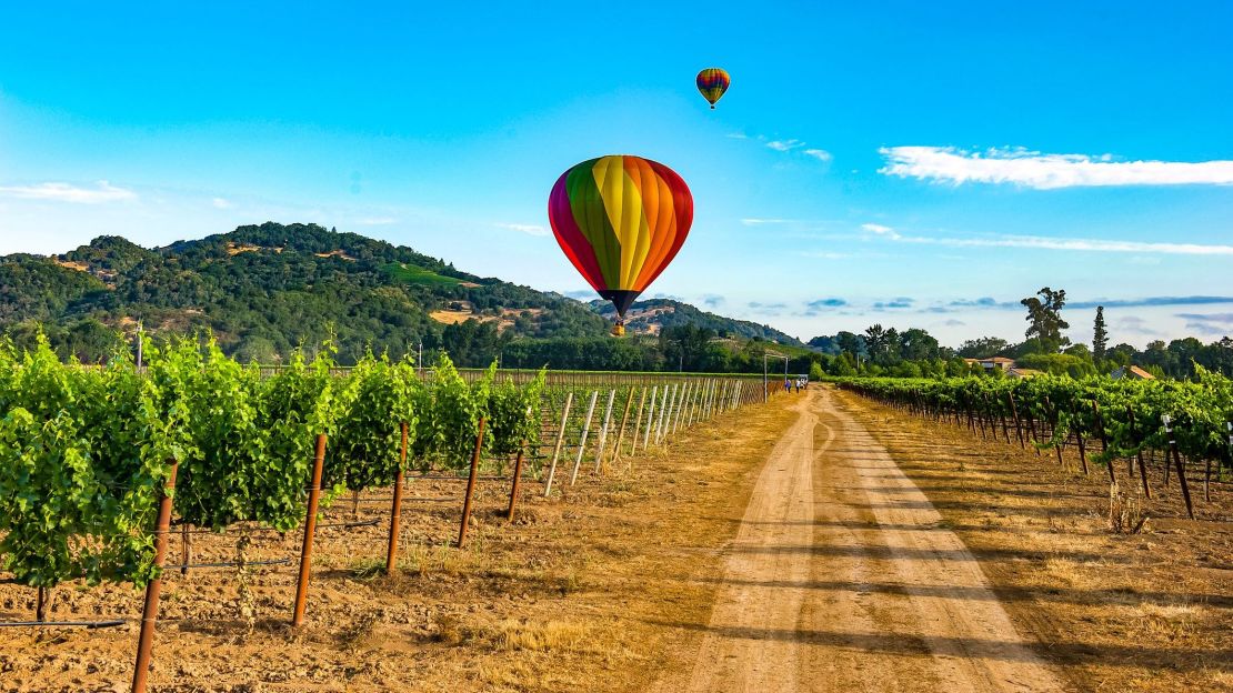 A photo of hot air balloons over a vineyard in Napa Valley, California