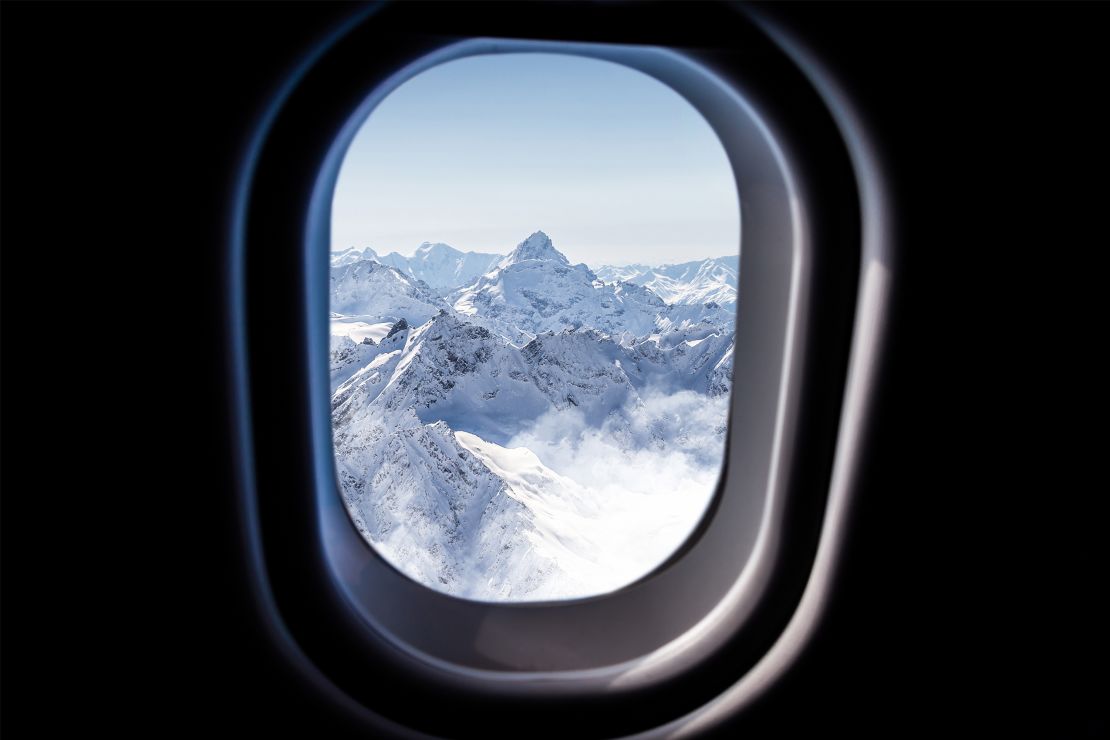 A photo of a snow-covered mountain from an airplane window
