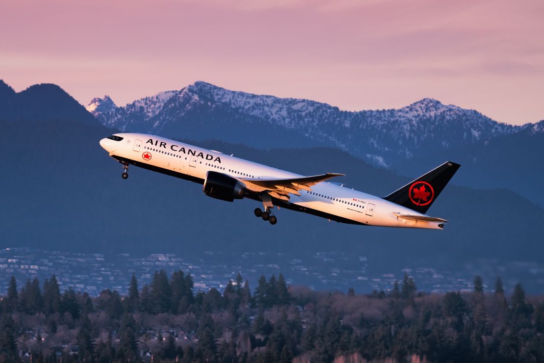 A photo of an Air Canada Boeing 777 taking off in Vancouver with mountains in the background