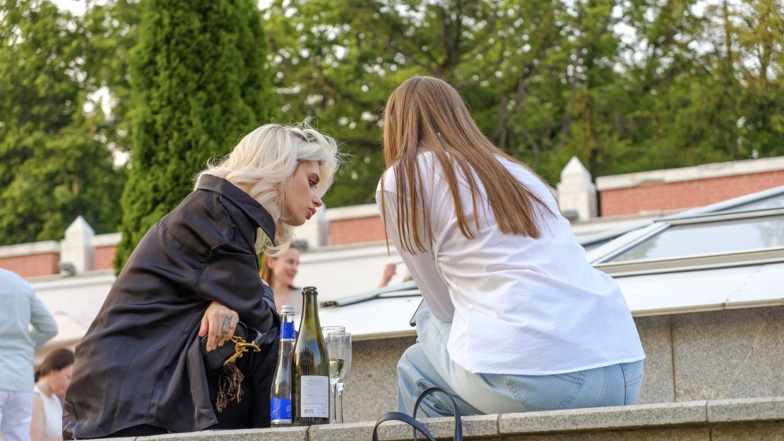 Two people drinking wine in a city