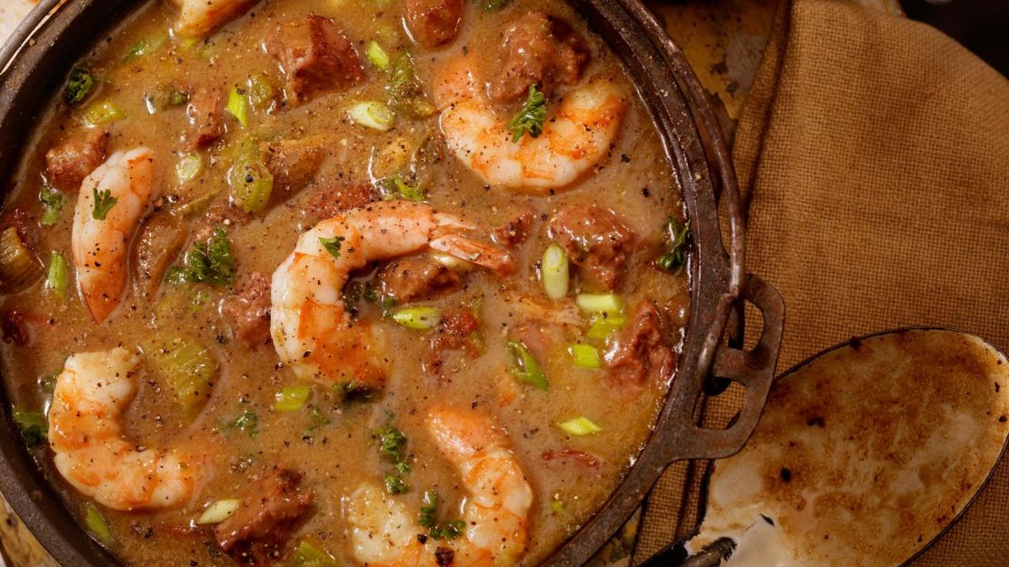 A photo of creole style shrimp and sausage gumbo in a cast iron pot