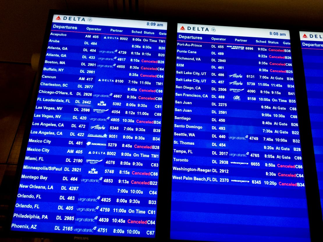 A photo of a flight information board showing canceled flights at New York-JFK airport