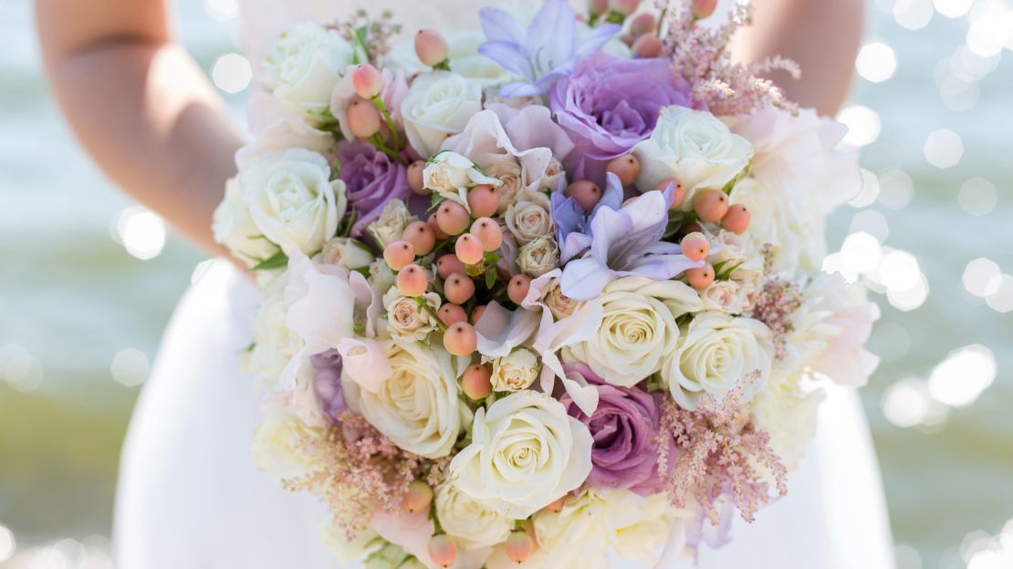 A photo of a bride's hands holding a bouquet of flowers