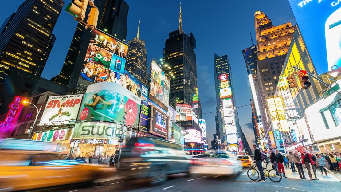 A photo of cars driving through Times Square at night