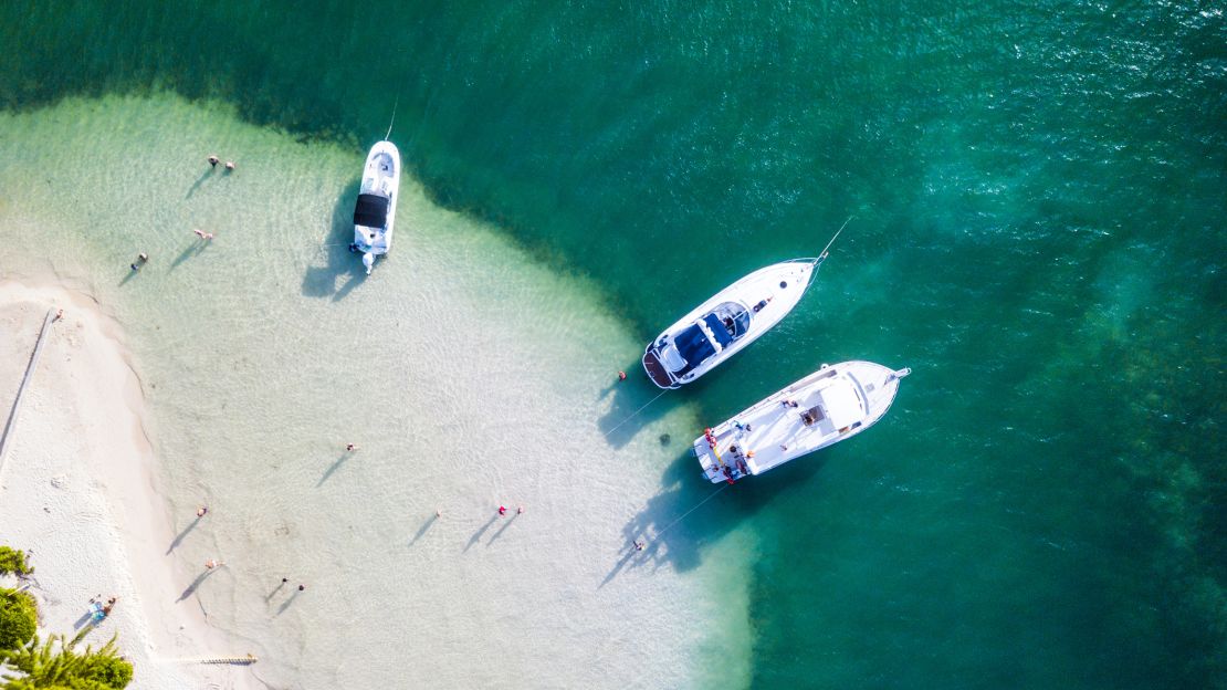 A photo of three boats parked near a beach in Grand Cayman, Cayman Islands