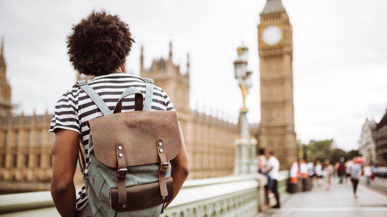 A photo of a person walking in front of the Big Ben clocktower in London, United Kingdom, while wearing a backpack