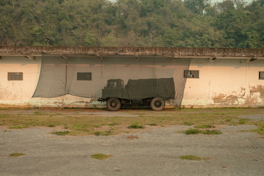 A former barracks and military truck sits at the end of the Long Tieng airstrip.