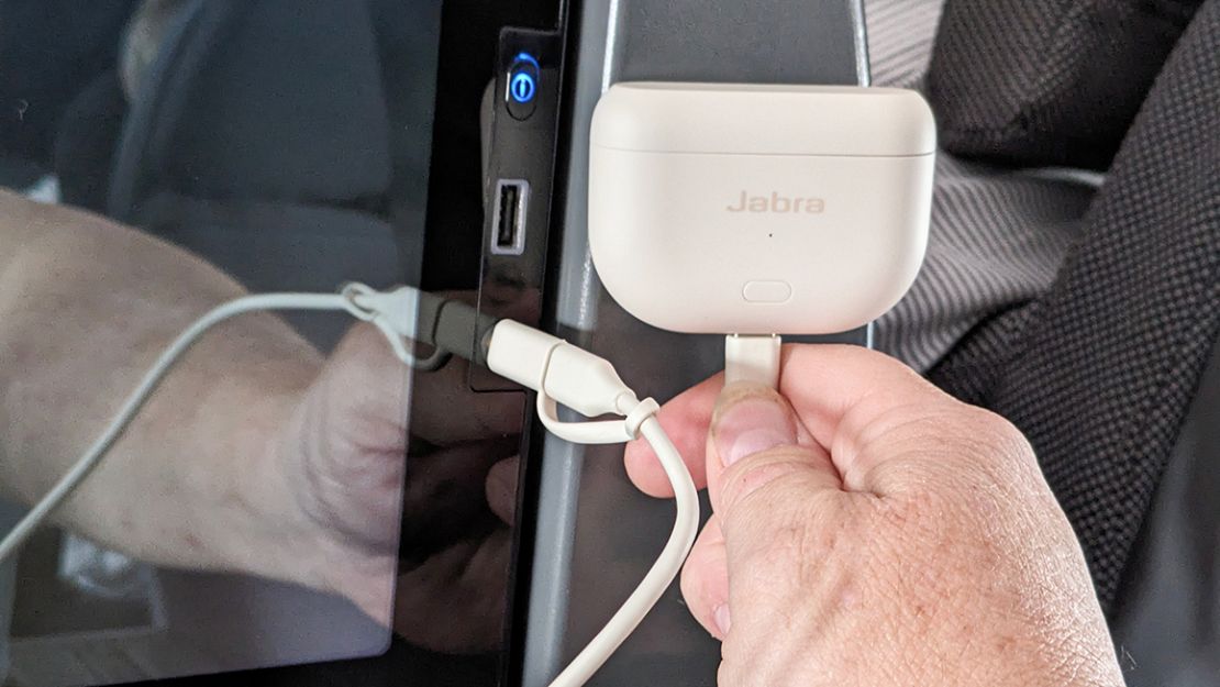 A hand plugged the Jabra Elite Gen 2 case into a port via a cable.