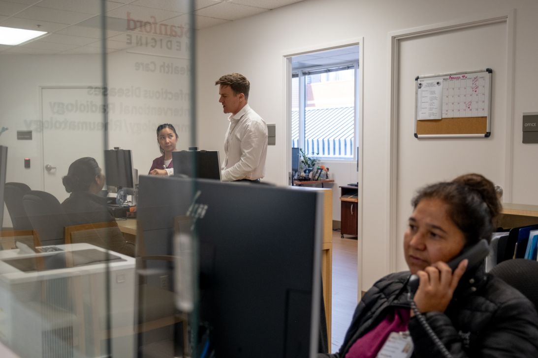 Dr. Jake Scott talks with colleagues at the Stanford Health Care Infectious Diseases Clinic.