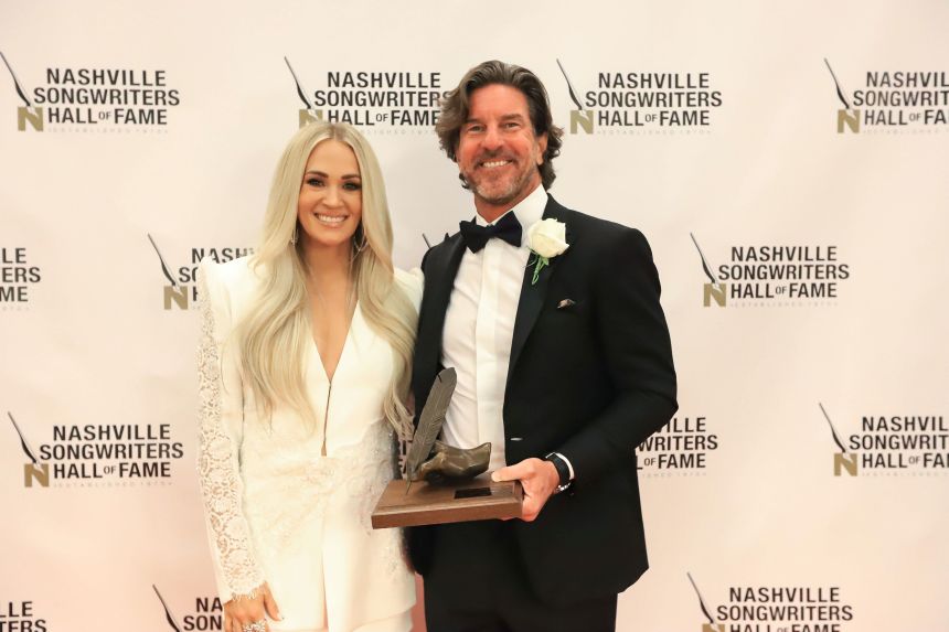Brett James and Carrie Underwood pose for a photo in 2021 after James was inducted into the Nashville Songwriters Hall of Fame.
