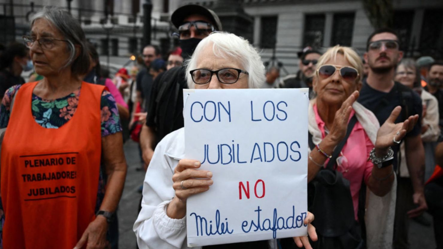 Una mujer sostiene un cartel durante una protesta convocada por jubilados que pedían un aumento de las pensiones frente al Congreso Nacional en Buenos Aires el 26 de febrero de 2025.