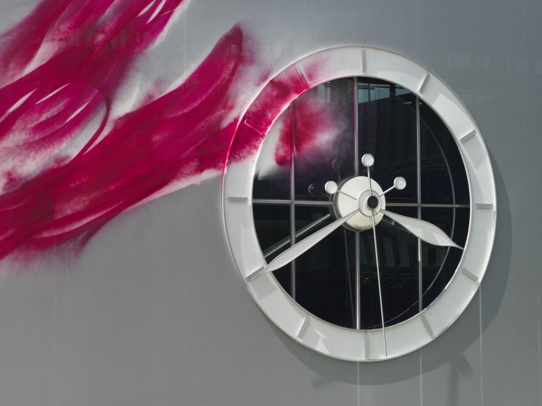 The paint covers structures like a fountain and a large clock on the facade of one of the exhibition halls.