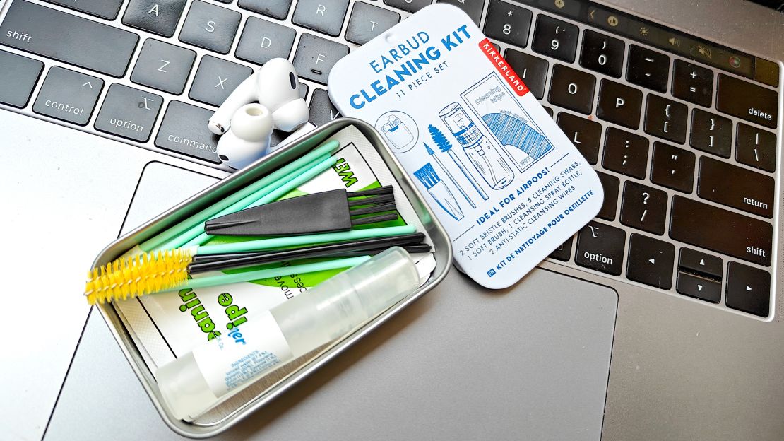 The Kikkerland Earbud Cleaning Kit is open on top of a laptop keyboard.