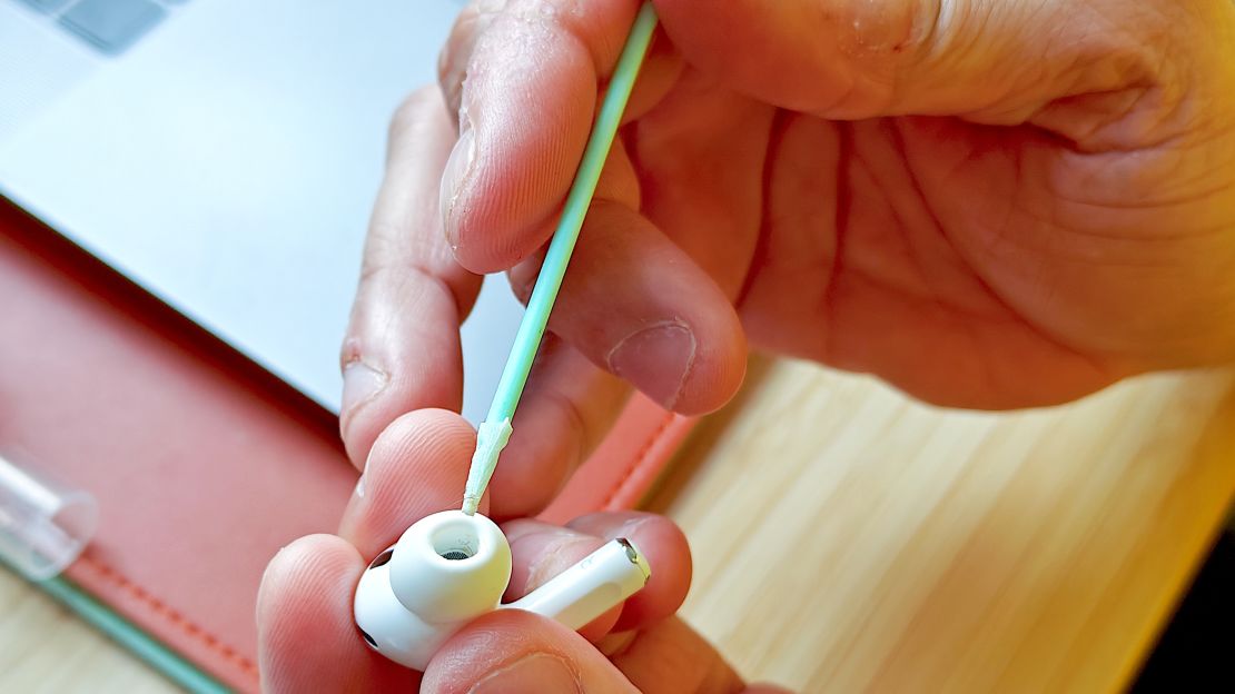 A soft bristle brush from the Kikkerland Earbud Cleaning Kit cleans an AirPod Pro.