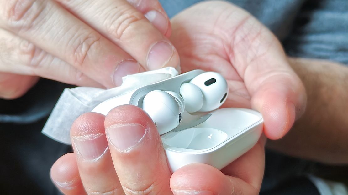 An anti-static wipe is used on the case of the Apple AirPods Pro.