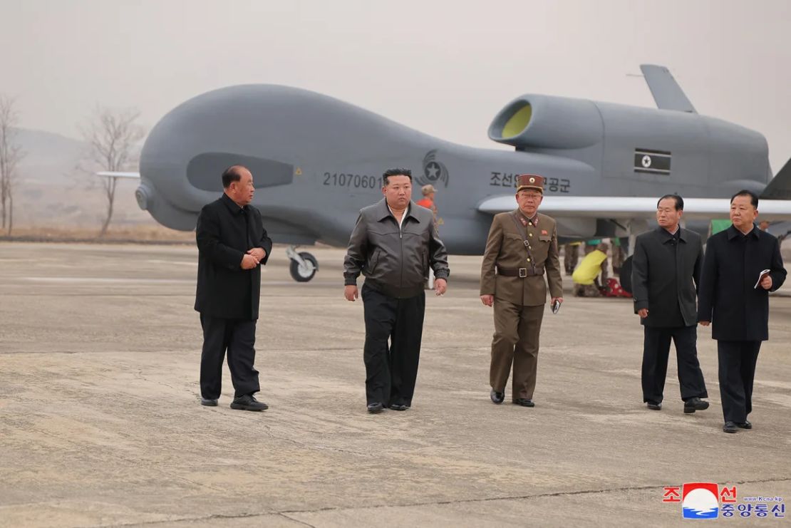 El líder norcoreano Kim Jong Un camina junto a funcionarios mientras inspecciona un gran dron de reconocimiento en esta fotografía publicada por la Agencia Central de Noticias de Corea del Norte el 27 de marzo de 2025.