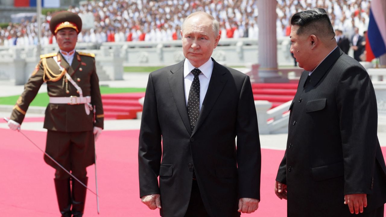 In this pool photograph distributed by the Russian state agency Sputnik, Russia's President Vladimir Putin (C) and North Korea's leader Kim Jong Un (R) attend a welcoming ceremony at Kim Il Sung Square in Pyongyang on June 19, 2024. Putin enjoyed a red carpet welcome, a military ceremony and an embrace from North Korea's Kim Jong Un during a state visit to Pyongyang where they both pledged to forge closer ties. (Photo by Gavriil GRIGOROV / POOL / AFP) / -- Editor's note : this image is distributed by the Russian state owned agency Sputnik --