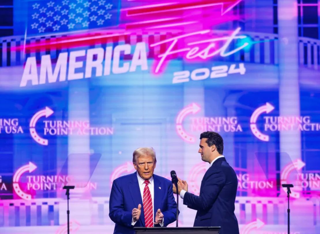 Charlie Kirk (derecha) aparece en el escenario con el presidente de Estados Unidos, Donald Trump, en el America Fest 2024 en Phoenix, Arizona, el 22 de diciembre de 2024.