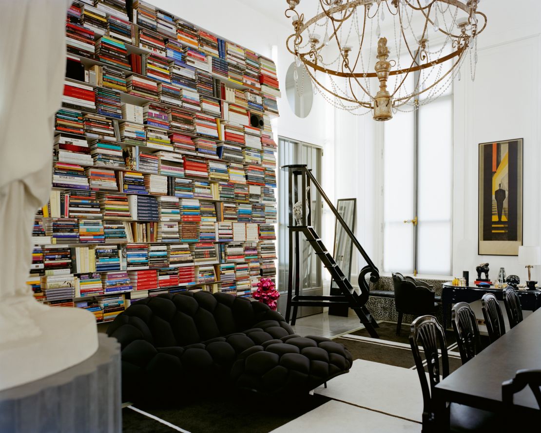 The library space inside Lagerfeld's apartment on Rue des Saints Pères in Paris, featuring artworks by Jeff Koons and Joana Vasconcelas (who designed the statue of the designer's cat, Choupette, that can be seen posing on the black ladder in the back of the photo) among others.
