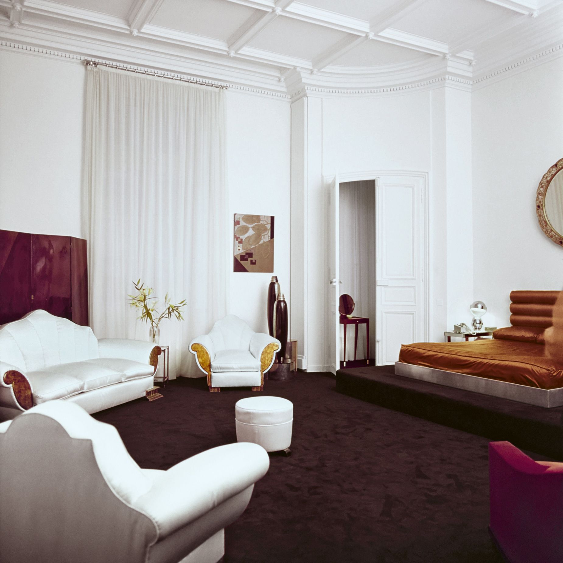 The apartment's living space and bedroom, featuring a "seashell" sofa and matching armchairs, as well as a modular platform bed.
