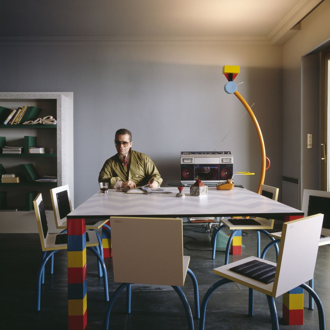Lagerfeld poses at the über-modern dining table in his Monte Carlo apartment, which he purchased in the early 19080s, a Diet Coke-filled glass (the designer was well-known for his love of the soda) at hand.