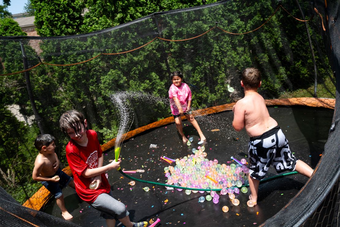 Graycen, Suri, and Junior play on a trampoline with friends during a going-away party.