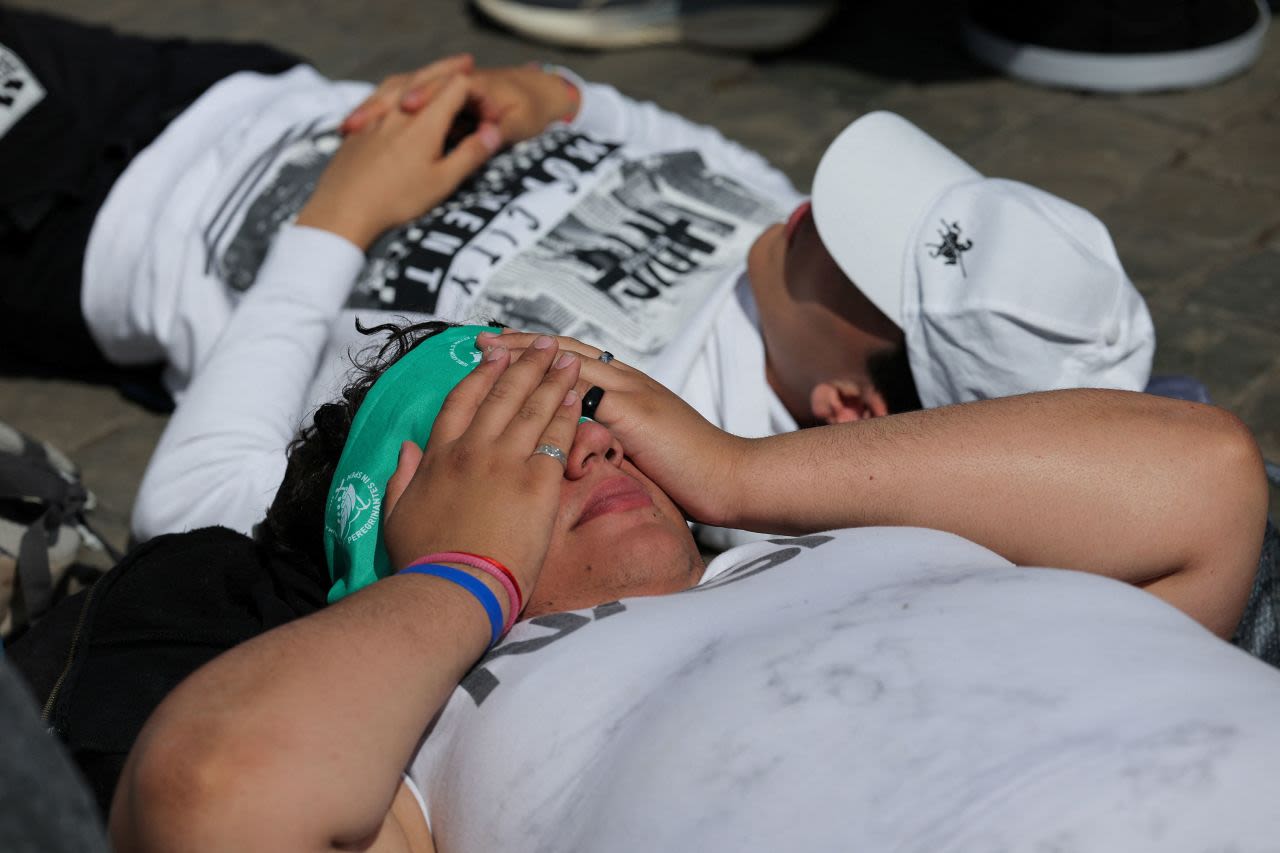 Un grupo de jóvenes juega a las cartas en la Plaza de San Pedro mientras esperan noticias de un nuevo papa el jueves.