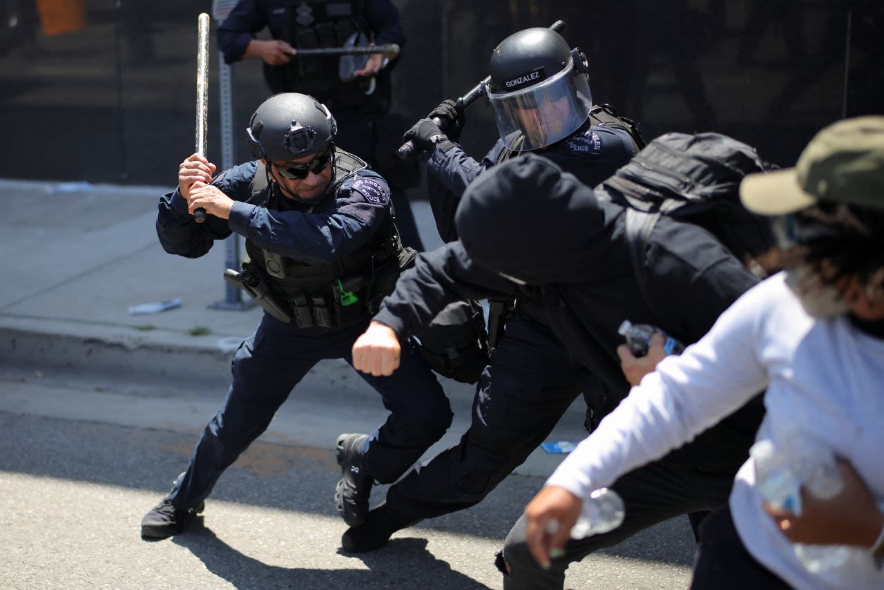 Agentes de la Policía Metropolitana de Los Ángeles blandieron sus porras contra los manifestantes durante una protesta contra las redadas federales de inmigración en Los Ángeles el domingo.