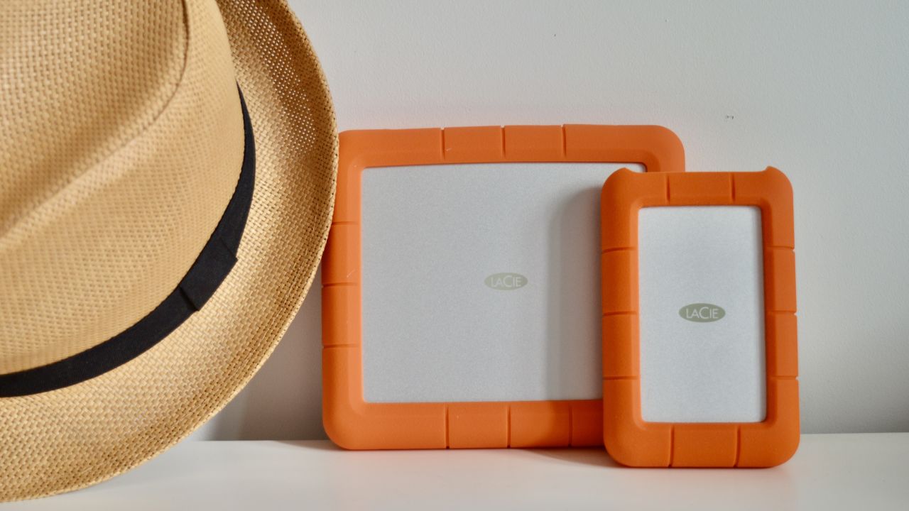 A photo of two LaCie Rugged Hard Drives next to a hat