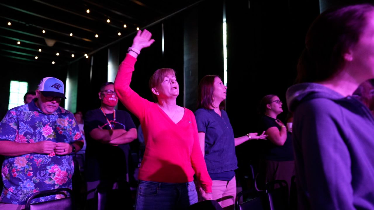 Larissa Miller, right, and her partner worship during a service at Watershed.