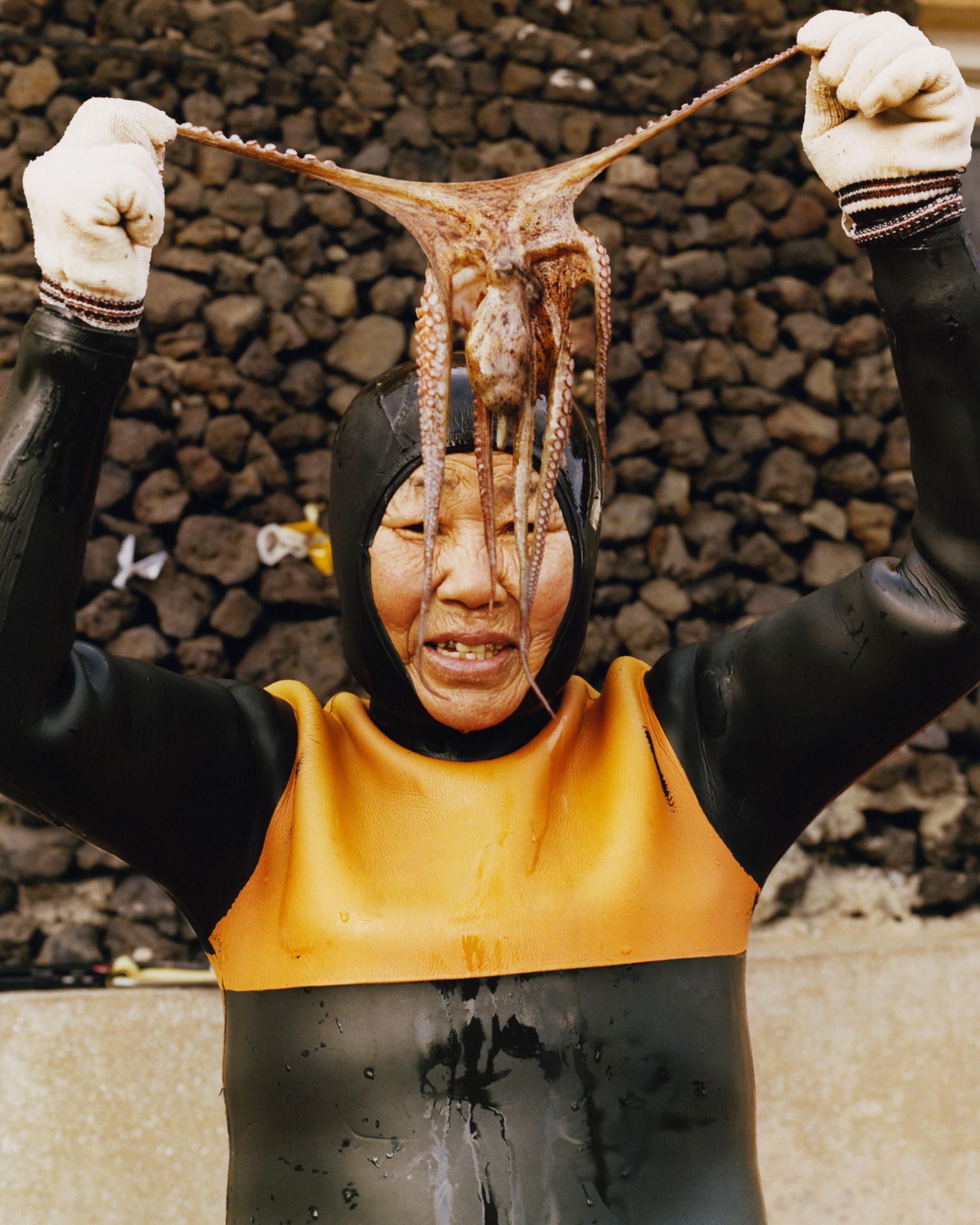 A Haenyeo diver shows off a small octopus, part of her catch.