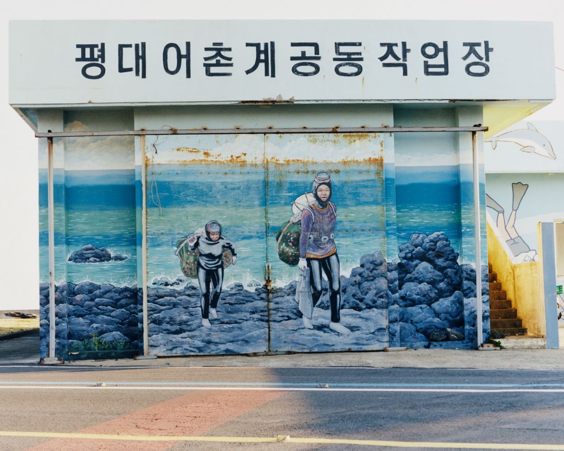 A mural depicts Haenyeo divers returning to shore with their filled nets.