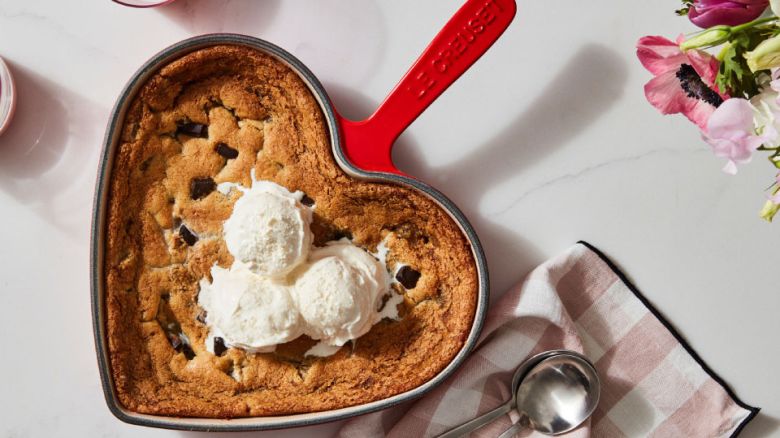 A heart-shaped cookie skillet topped with ice cream.