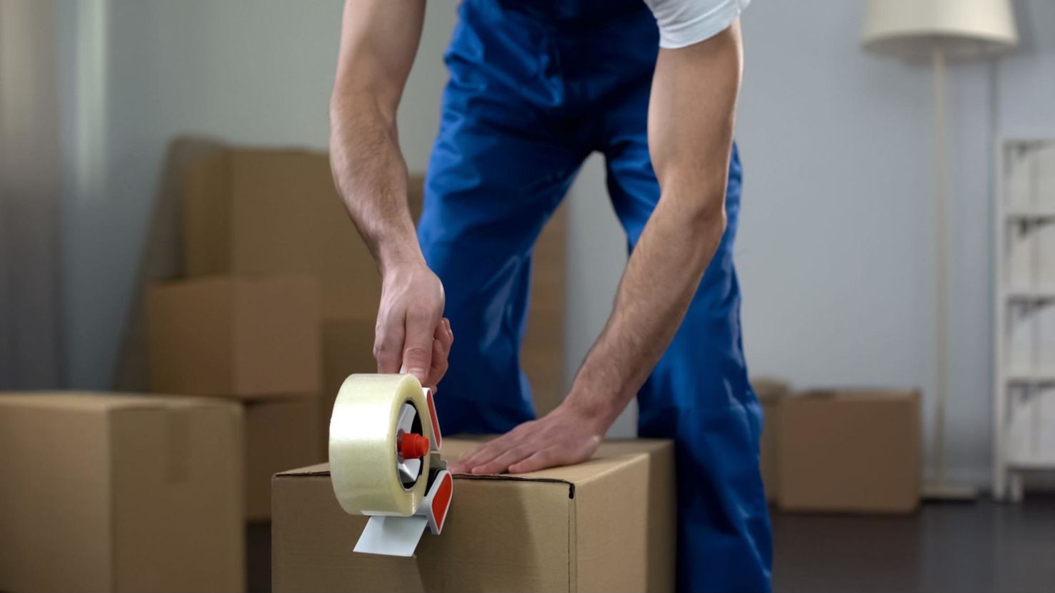 Moving crew member tapes up a box.