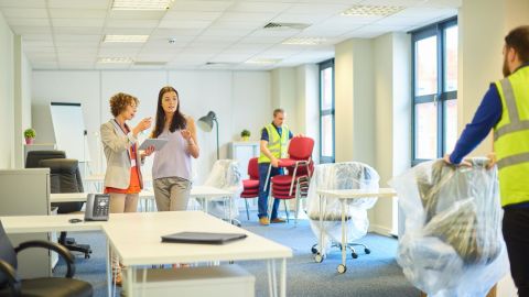 Commercial movers unpacking office furniture and reassembling the office space.