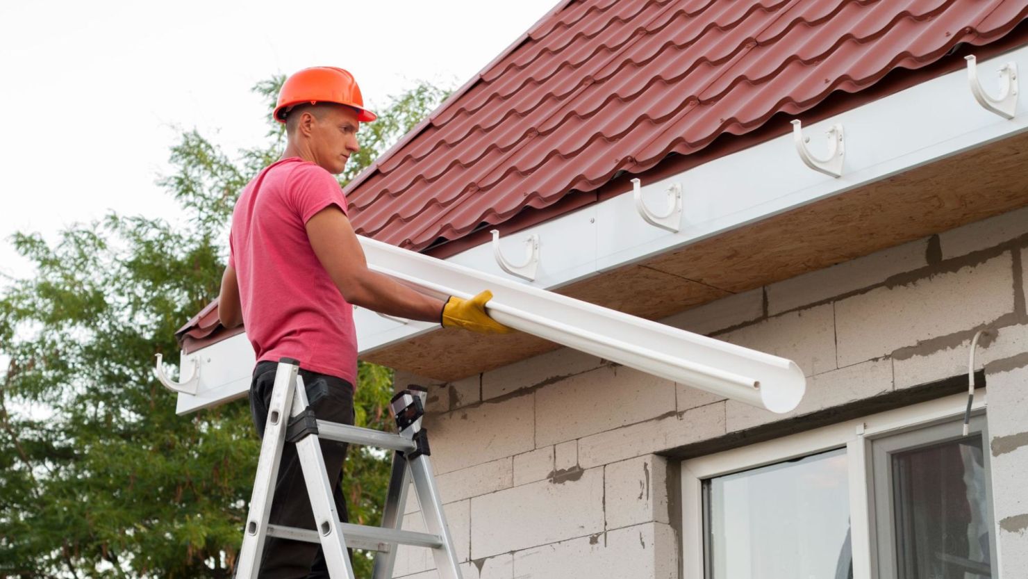 Homeowner installing gutters on their roof