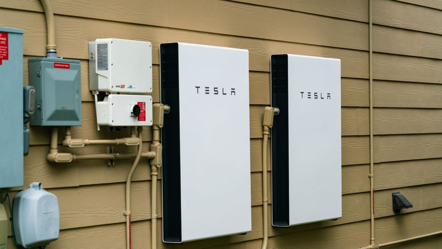 Two Tesla Powerwall solar batteries installed on a residential home.