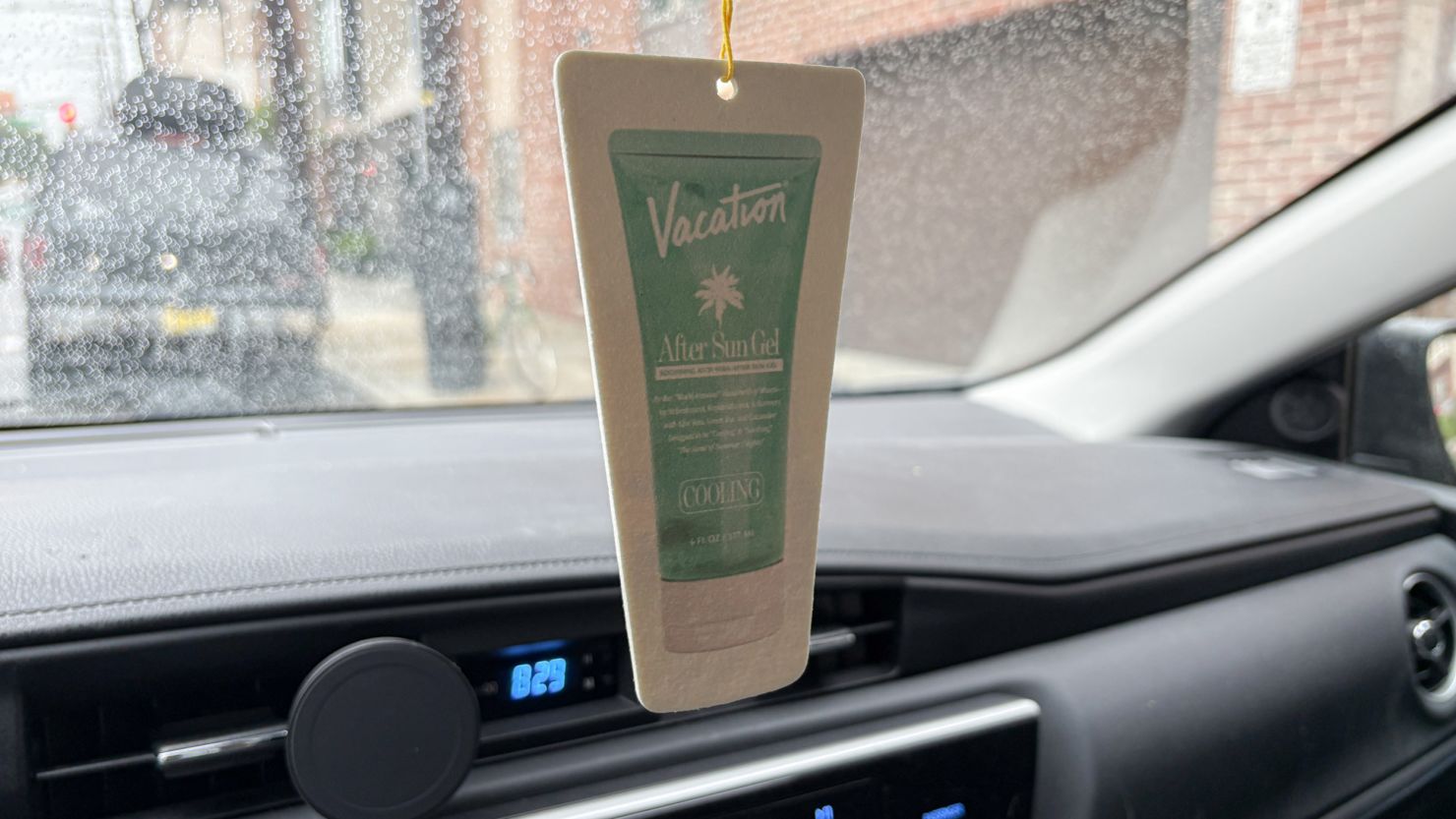 Vacation After Sun Car Air Freshener hanging from a car mirror