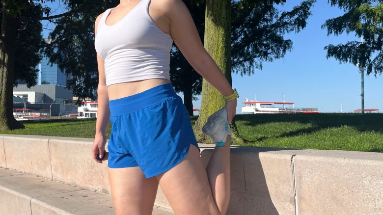 Woman standing stretching in blue shorts